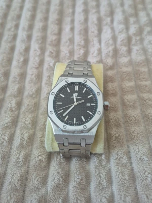 Stainless steel silver klocka - Snyggt silver klocka och svart urtavla. Klockan har en åttakantig boett, tydliga indexmarkeringar och datumvisning. Perfekt accessoar för dig som gillar en modern och clean look. Kommer med extra länkar ifall det inte passar. 