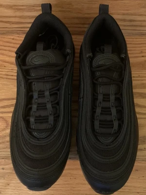 Nike Air Max 97 Triple Black sneakers - Som nya, orginal skor från nike, testade några gånger, luktar fortfarande nytt om de storlek 40,5 