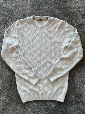 Ljusgrå stickad tröja från Stenströms  - Snygg ljusgrå stickad tröja med diskret geometriskt mönster. Nypris 2500kr säljer för den är för stor och inte används.
