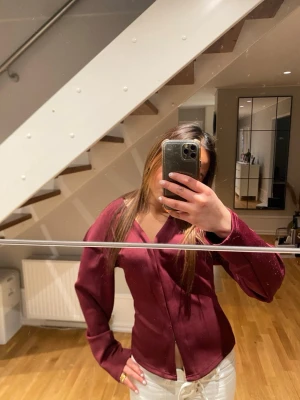 Vinröd blus med v-ringning - Snygg vinröd blus med v-ringad hals och långa ärmar. Passar super bra med allt!