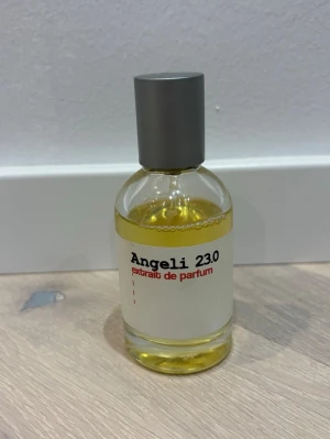 Angeli 23.0 extrait de parfum - Angeli 23.0 extrait de parfum i en stilren, rund glasflaska med grå kork. Parfymen har en guldfärgad vätska och etiketten är vit med svart och röd text. Perfekt för dig som gillar minimalistisk design och exklusiva dofter.Finns tyvärr ingen box till den