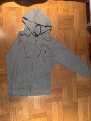 Grå zip-hoodie från Polo Ralph Lauren - Nypris:2495kr. Digitalt kvitto finns. Grå Ralph Lauren hoodie Storlek L, passar även Storlek M.