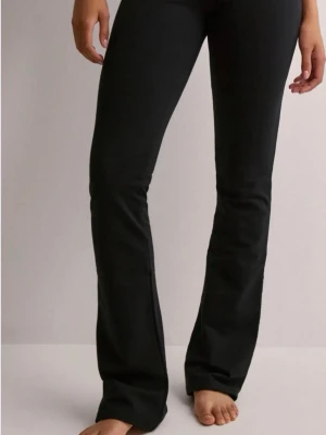 Svarta bootcut leggings - Snygga svarta leggings med bootcut-modell och hög midja. Stretchigt material som sitter skönt och formar sig efter kroppen. Perfekta till en avslappnad look eller när du vill känna dig extra bekväm. Inga synliga fickor eller detaljer.