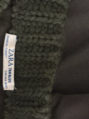 Mörkgrön topp från Zara Trafaluc - Snygg mörkgrön topp från Zara Trafaluc med grovstickad krage. Toppen har en enkel design med rund halsringning och är perfekt för en stilren look. Materialet känns mjukt och bekvämt mot huden. Använt ett par gånger men säljer för jag inte har användning för det! 💛