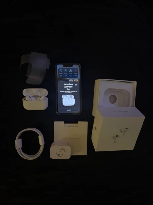 Apple AirPods Pro med laddningsetui - Säljer ett par Apple AirPods Pro med trådlöst laddningsetui. Hörlurarna är vita och har en stilren, minimalistisk design. Medföljer originalkartong, laddningskabel och extra öronproppar. Perfekta för musik, samtal och träning.