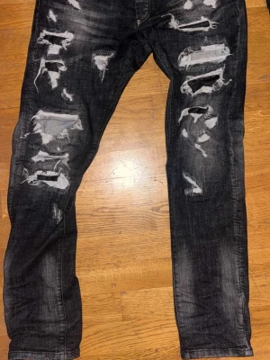 Philip Plein - Säljer ett par svarta jeans från pp ÄKTA med kraftiga slitningar och trasiga detaljer på både fram- och baksida. Jeansen har en tvättad look och raka ben. Materialet är klassisk denim som ger en cool och trendig vibe. Äkta och kvitto från farfetch fås med, Pris går att bolla med