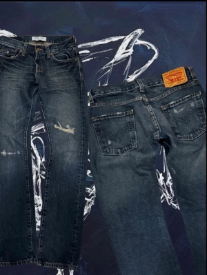 Levi's 511 mörkblå jeans herr - Säljer ett par Levi's 511 jeans i mörkblå tvätt med slitningar och klassiska fem fickor. Jeansen har en rak passform och är tillverkade i slitstarkt bomullsjeansmaterial. Perfekta för dig som gillar en tidlös och avslappnad stil. Sitter som storlek 29/31. Skriv för mer info!