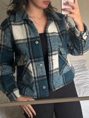 Blåvit rutig teddycardigan - Mysig blå och vit rutig cardiganjacka i teddy-material med knappar framtill och krage. Jackan har långa ärmar och två sidofickor. Perfekt för lager på lager och ger en trendig look med sitt fluffiga material och avslappnade passform. Kolla min profil för fler plagg! 🥰