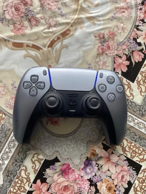 PlayStation 5 DualSense handkontroll - Säljer en PlayStation 5 DualSense handkontroll i svart och grått. Kontrollen har en ergonomisk form, två analoga spakar, touchpad, inbyggd mikrofon och klassiska PlayStation-knappar. Perfekt för gaming på PS5 och har LED-ljus vid touchpaden.