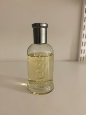 Hugo Boss parfymflaska - Den klassiska Boss Bottled, EdT från Hugo Boss har toppnoter av citrusfrukter, mellantoner av kanel och kryddnejlika samt basnoter av ceder och sandelträ. 100ml flaska, men ca 80ml kvar. 