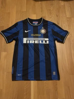 Inter Milan matchtröja Eto'o #9 - Säljer en blåsvart randig Inter Milan matchtröja från Nike med Pirelli-logga på bröstet och Eto'o samt nummer 9 på ryggen. Tröjan har klubbmärke, guldfärgad text och vita detaljer vid krage och ärmslut. Perfekt för fotbollsfans! Den är också retro!