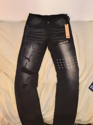 Ksubi jeans size 29 - Säljer ett par svarta skinny jeans med slitningar, vita kors- och textdetaljer på benen. Jeansen har en modern, tvättad look och är perfekta för dig som gillar streetwear och vill sticka ut. Materialet är denim med stretch för extra komfort.