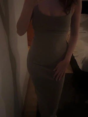 Mörk-grön  tight axelbandsklänning - Säljer en mörkgrön axelbandsklänning från Bershka.  Passformen är figurnära  och har en lång längd. 