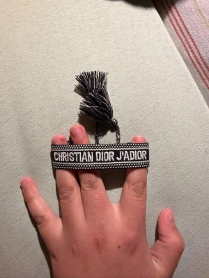 Armband - Snyggt svart och vit  Armbandet har justerbar knytning med tofsar och är perfekt för att ge din outfit en lyxig touch. Broderad design och trendig look.