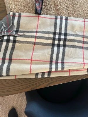 Burberry halsduk - Burberry halsduk med två sidor med beige och andra grå. Snygg halsduk 