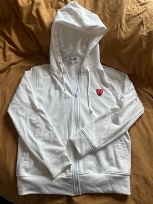 Vit hoodie från Comme des Garçons Play - Säljer en vit hoodie med dragkedja från Comme des Garçons Play. Skriv om du har några frågor.