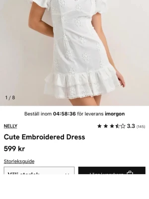 SÖKER!!  klänning från Nelly - Söt vit kortklänning från Nelly med broderade blommor, volangkant nertill och puffärmar. Klänningen har en feminin och romantisk look med fina spetsdetaljer och är perfekt för varma dagar.