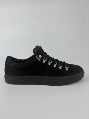 Mörkbruna Diemme mockasneakers med metallhakar - Stilrena sneakers i mörkbrun mocka med robusta bruna snören och coola metallhakar för en unik look. Skorna har en låg siluett och en matchande mörkbrun sula. Perfekta för dig som vill ha något som sticker ut men ändå är klassiskt.