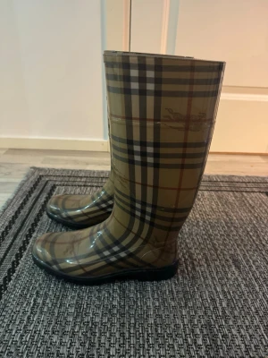 Burberry rutiga gummistövlar - Jättefina burberry stövlar som jag köpt för längesen. Använda ett par fåtal gånger och har bara stått sen dess. Har tyvärr inte boxen eller kvitto kvar då jag inte tänkt sälja vidare dom 🥰 