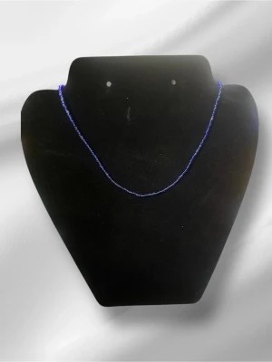 Blått halsband med små pärlor - Snyggt halsband med små, blå pärlor som ger en minimalistisk och trendig look. Perfekt för dig som gillar enkla men stilrena accessoarer. Halsbandet har en tunn och smidig design som passar till många olika outfits. Halsbandet är handgjordt