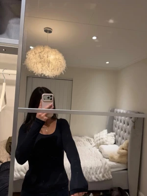 Svart långärmad topp med rund hals - Snygg svart långärmad topp med rundad urringning och figurnära passform. Perfekt basplagg att styla till olika looks. Mjuk och stretchig känsla, passar till allt från jeans till kjol.