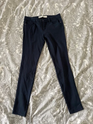 Mörkblå leggings jeans från Abercrombie & fitch  - Slimmade mörkblå leggings från Abercrombie & Fitch med klassisk femficksdesign och stretchigt material. Perfekt passform med smala ben och bekväm midja. Materialet är mjukt och följsamt, vilket gör dem sköna att bära hela dagen.