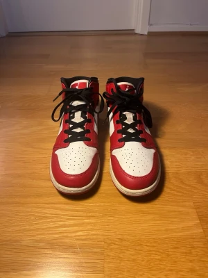 Nike Air Jordan 1 Mid Chicago storlek 40 - Säljer ett par Air Jordan 1 Mid Chicago i storlek EU 40. Klassisk Chicago-inspirerad färg i rött, vitt och svart. Skorna är i bra skick med lite normalt slitage och veck från användning. Sulor och skorna helhet i fint skick.