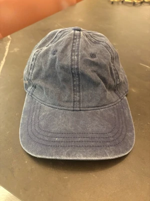 Mörkblå ”jeans” keps - Jag säljer en keps som är mörkblå och ser nästan ut som jeans färg i med att designen ska vara lite sliten💕