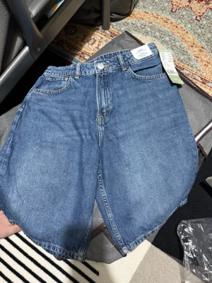 Blå denimshorts från H&M - Säljer ett par klassiska blå denimshorts från H&M. Shortsen är helt ny och kommer med prislappen!  Storlek 158!