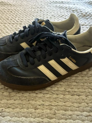 Adidas Samba blå - Klassiska Adidas Samba sneakers i svart läder med vita detaljer och bruna gummisulor, storlek 38❤️
