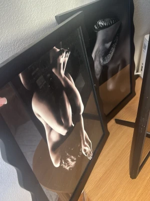 Tavla  - Två svartvita tavlor med konstnärliga fotografier av kroppar och läppar. Båda bilderna är inramade i svarta ramar med glas. Perfekt som modern väggdekoration för ett stilrent hem.
