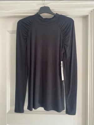 Svart topp med scrunch - Jättefin topp ifrån stories i storlek XS men passar även en S. Aldrig använd och den har prislappen kvar-den är endast testad.   🌸Super fina axlar som är lite volang/vågiga.  🌸tröjan sitter extremt fint på kroppen 🌸passar till allt, kontorsarbete, kalas, fest, vardag  