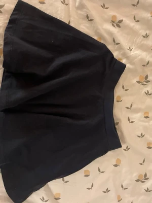 Kjol i bomull barn st 120 - Enkel och snygg mörkblå kjol från lager 157 med utsvängd passform. Kjolen är gjord i mjukt bomullstyg och har resårband i midjan. Barn storlek 120