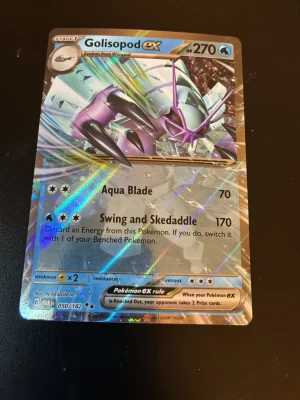 Golisopod EX Pokémonkort holo - Säljer ett Golisopod EX Pokémonkort med holografisk yta. Kortet har 270 HP och attacker som Aqua Blade och Swing and Skedaddle. Kortet har en cool design med lila och silverfärger och är från serien Sword & Shield. Perfekt för samlare eller Pokémonfans.