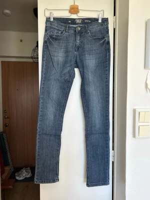 Blå raka jeans - Snygga blå jeans med rak passform och klassisk femficksdesign. Jeansen har en lätt tvättad look och normal midja. Materialet är mjukt och stretchigt för extra komfort.