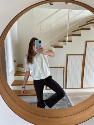 Vit kortärmad kofta med knappar - Säljer en söt vit kortärmad kofta med pärlemorknappar framtill. Koftan har en mjuk, fluffig textur och rak passform. Är i st. L, jag brukar ha s men passar ganska bra om man vill ha lite overzised.