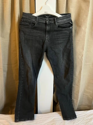 Gråa Replay jeans - Ett par riktigt snygga och välvårdade jeans från premiummärket Replay. Jeansen har en mörkgrå, lätt tvättad finish och är i mycket fint skick, nästan som nya! Detaljer: • Märke: Replay • Storlek: 166 cm (enligt storlekslapp, se bild 5). Det motsvarar ungefär storlek 16 år eller en mindre vuxenstorlek (XS/S). Dubbelkolla gärna dina egna mått. • Modell: Klassisk 5-ficksmodell med gylf och knapp fram. • Skick: Mycket bra skick, inga synliga fläckar, hål eller tecken på slitage!