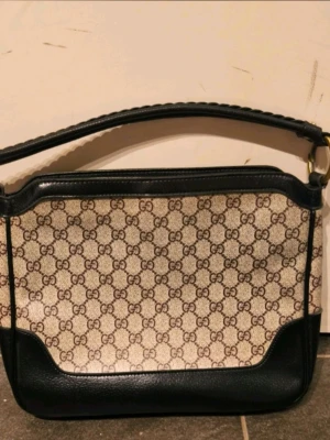 Hobo-väska - Väska med flätad axelrem (och längre axelrem i läder, fråga efter bilder). Remmarna är avtagbara eftersom ringarna kan öppnas som ett spänne.  Inuti läderetikett och datumkod.  Ett stort fack och en ficka med dragkedja.  Bredd: 30 cm Höjd: 25 cm Djup: 7 cm