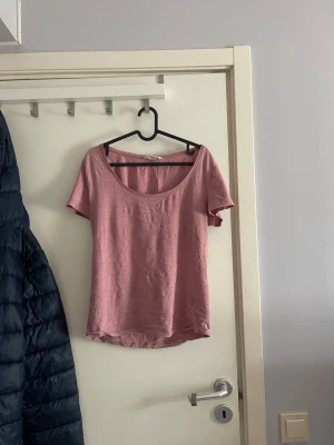 Rosa kortärmad topp med rund hals - En enkel och snygg rosa topp med rund halsringning och korta ärmar. Perfekt att matcha med jeans eller kjol för en avslappnad look. Tillverkad i mjukt bomullsmaterial som känns skönt mot huden.