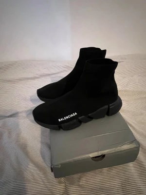 Balenciaga  - Svarta Balenciaga Speed Trainer sneakers med strumpliknande ovandel i stretchigt tyg och chunky svart sula. Minimalistisk design med vit Balenciaga-logga på sidan. Perfekta för dig som gillar bekväma skor
