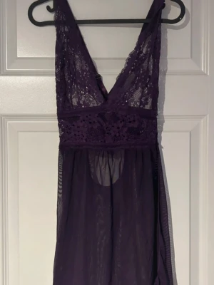 Nattlinne i spets  - Snyggt nattlinne i mörklila med djup V-ringning och justerbara korsade axelband i ryggen. Överdelen är dekorerad med blommig spets och underdelen i tunn mesh som ger en luftig och elegant känsla(ifrån shein) 