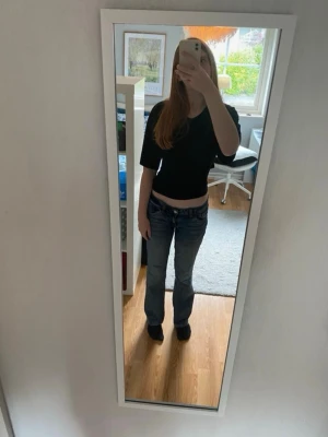 Svart tie-topp - Säljer en svart croppad topp med snygg knytning i ryggen. Toppen har en enkel, stilren design och är perfekt för dig som gillar trendiga detaljer. Materialet känns mjukt och bekvämt.