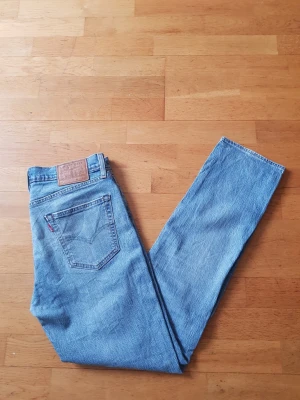 Levi's ljusblå raka jeans - Klassiska ljusblå jeans från Levi's med rak passform och femficksdesign. Jeansen har den ikoniska läderpatchen bak i midjan och synliga sömmar på bakfickorna. Tillverkade i slitstark denim med vintagekänsla.