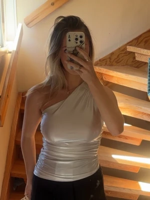 Silver oneshoulder topp - Snygg silverfärgad oneshoulfer topp. Mycket stretchigt material och passar bra med lågmidjade byxor. Storlek S🌸