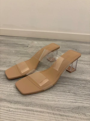 Beige sandaler med transparent klack - Snygga klackar från Pull&Bear i storlek 40. Bekväma att gå i med stabil klack och stilren design. Endast använda en gång!! och i mycket bra skick. Säljes då de tyvärr är för stora för mig. Perfekta både till vardag och fest 🌸