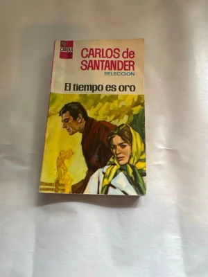 El tiempo es oro av Carlos de Santander - En spansk pocketbok med titeln 'El tiempo es oro' av Carlos de Santander. Omslaget har en färgstark illustration med gula, gröna och bruna toner samt rosa rygg. Perfekt för dig som gillar romantisk skönlitteratur på spanska.