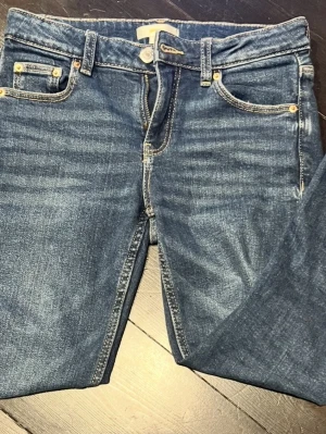 Mid rise blåa utsvängda jeans💙 - Snygga blå  utvända och mid rise jeans med klassiska fickor. Jensen haf ett litet hål i knät och är väldigt fina. Från Gina och i storlek 146 Perfekta för en avslappnad och trendig look. Skriv vid fler frågor!🫶