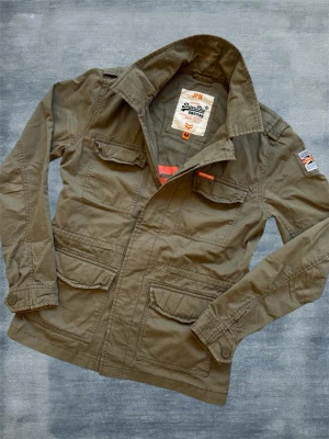 Superdry Fieldjacket - En mycket trevlig fieldjacket från Superdry i en fin ton av grön! Hör av dig vid frågor! 