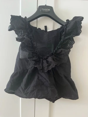 Svart volangblus med spetsdetaljer - Supersöt svart blus från hm med volangkant och spetsdetaljer. Storlek xs. 