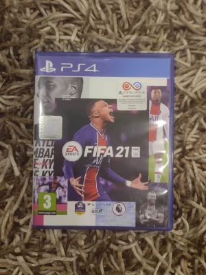 FIFA 21 till PS4 - FIFA 21 till PlayStation 4, ett fotbollsspel med realistisk grafik och officiella lag och spelare. Omslaget är blått och spelet levereras i ett plastfodral med skiva och manual. Perfekt för dig som gillar sportspel och vill utmana vänner online.